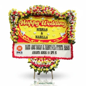 Papan bunga wedding warna kuning dan merah dengan desain cerah untuk menyampaikan ucapan selamat menikah secara berkesan.